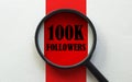 Magnifier with text 100K Followers on the white and red background Royalty Free Stock Photo