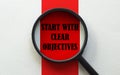 Magnifier with text START WITH CLEAR OBJECTIVES on the white and red background