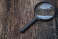 Magnifier on wood board background Royalty Free Stock Photo