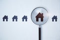 Magnifier zooming in on house icon on white background. Home and property search concept. Royalty Free Stock Photo