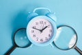 magnifiers and alarm clock on a blue background