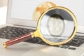 Magnifying glass with bitcoin inside on laptop with earth globe on screen Royalty Free Stock Photo