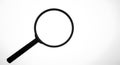 Magnifying glass with a black handle and circular frame, viewed against a plain Royalty Free Stock Photo