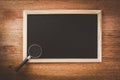 Magnifying glass on blank slate chalk board, vintage tone Royalty Free Stock Photo