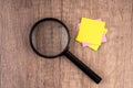 Magnifying glass and blank yellow adhesive note Royalty Free Stock Photo