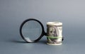 Magnifying glass and a bundle of money. Concept of fundraising, attracting investments. Loan to paycheck, urgent loans.