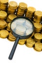 Magnifying glass and coins Royalty Free Stock Photo