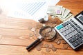 Magnifying glass, coins, calculator and statistics on the table