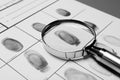 Magnifying glass and criminal fingerprint card