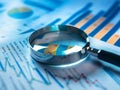 Magnifying glass and documents with analytics data lying on table,selective focus Royalty Free Stock Photo