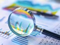 Magnifying glass and documents with analytics data lying on table,selective focus Royalty Free Stock Photo