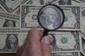 Through the magnifying glass of the dollar is a portrait of late American President George Washington.