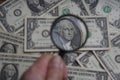 Through the magnifying glass of the dollar is a portrait of late American President George Washington.