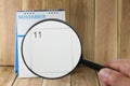 Magnifying glass in hand on calendar you can look eleventh day o