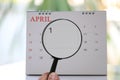 Magnifying glass in hand on calendar you can look first day of m