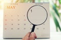 Magnifying glass in hand on calendar you can look first day of m