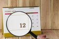 Magnifying glass in hand on calendar you can look twelfth day of