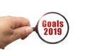 Magnifying glass in hand and a Goals 2019 text on the white background