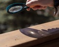 A magnifying glass in the hands of a man who teaches a child to make a fire with a magnifying glass Royalty Free Stock Photo