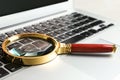 Magnifying glass on keyboard of laptop, closeup. Search concept