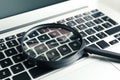 Magnifying glass on keyboard of laptop, closeup. Search concept