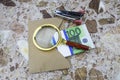 A magnifying glass lies on an envelope with a bundle of 100 euros on the table