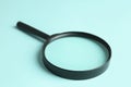 Magnifying glass on blue background, closeup. Search concept