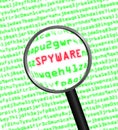 Magnifying glass locating spyware in computer code Royalty Free Stock Photo