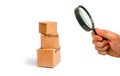Magnifying glass is looking at the Cardboard boxes on a white background. The concept of packing goods, sending orders Royalty Free Stock Photo