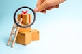 Magnifying glass is looking at the gift box on a pile of boxes. The concept of finding the perfect gift. Limited offer Buy a gift Royalty Free Stock Photo