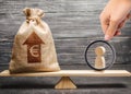 Magnifying glass is looking at a man figurine and Euro money bag with arrow up on scales. average salary in the labor market Royalty Free Stock Photo