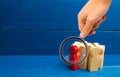 Magnifying glass is looking at the Red man stands out from group, Crowd, meeting, social activity. Group people figurines. Society Royalty Free Stock Photo