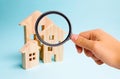 Magnifying glass is looking at the Three houses. Buying and selling of real estate, construction. Apartments and apartments. City