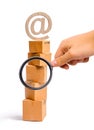 Magnifying glass is looking at the tower of cardboard boxes and an email symbol on top. concept of online sales, shopping and Royalty Free Stock Photo