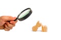 Magnifying glass is looking at a wooden figure of a man is broken. The concept of psychological stress and pressure. Could not sta Royalty Free Stock Photo