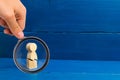 Magnifying glass is looking at the wooden figure of a man with a crack. The concept of psychological stress and pressure. Could no Royalty Free Stock Photo