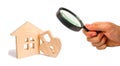 Magnifying glass is looking at the Wooden house with Heart shaped lock on a white background. Love nest, relationships. Buying a h Royalty Free Stock Photo