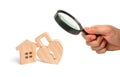 Magnifying glass is looking at the Wooden house with Heart shaped lock on a white background. Love nest, relationships. Royalty Free Stock Photo