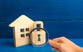 Magnifying glass is looking at the Wooden house with a padlock. House with a lock. Security and safety, collateral, loan for a mor Royalty Free Stock Photo