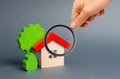 Magnifying glass is looking at a wooden house and trees. Environmentally friendly and environmentally friendly home. Quiet