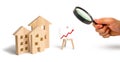 Magnifying glass is looking at the Wooden houses stand with red arrow up. Growing demand for housing and real estate. The growth o Royalty Free Stock Photo