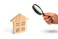 Magnifying glass is looking at the Wooden residential house on a white background. Isolate Real estate concept, buying affordable Royalty Free Stock Photo