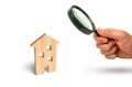 Magnifying glass is looking at the Wooden residential house on a white background. Isolate Real estate concept, buying affordable Royalty Free Stock Photo