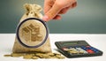 Magnifying glass looks at money bag with coins and a calculator. Profit calculation and income analysis. Interest rates.