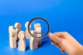 A magnifying glass looks at a people figurines stand in a circle. discussion, cooperation. Meeting at work Royalty Free Stock Photo