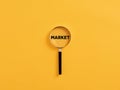 Magnifying glass or magnifier focusing on the word market. Business market strategy or focusing on target market analysis