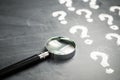 Magnifying glass and many question marks Royalty Free Stock Photo