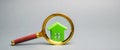 Magnifying glass and miniature wooden house. House searching concept. Home appraisal. Property valuation. Choice of location for