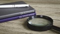 Magnifying glass and notebooks titled "QUALITATIVE" and "QUANTITATIVE," symbolizing data analysis Royalty Free Stock Photo
