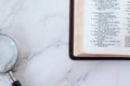 Magnifying glass and open holy bible book of psalms on white marble background Royalty Free Stock Photo